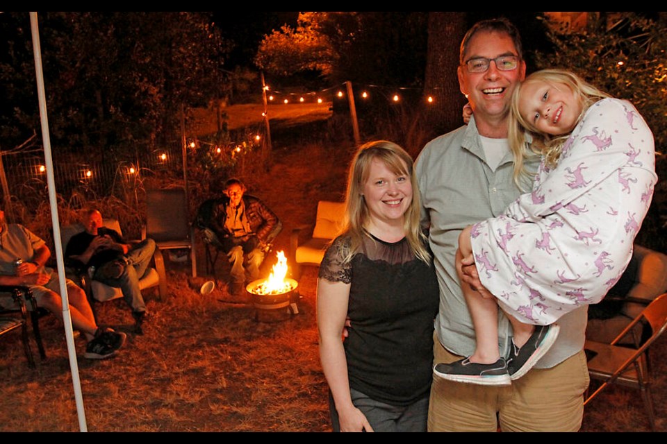 Langford mayor-elect Scott Goodmanson, his wife Katey Earl and their five-year-old daughter Hazel celebrate by a campfire on Saturday night. Goodmanson, a Saanich resident who grew up in Langford, defeated seven-term mayor Stew Young. Goodmanson’s humble campaign headquarters consisted of a small tent trailer. ADRIAN LAM, TIMES COLONIST