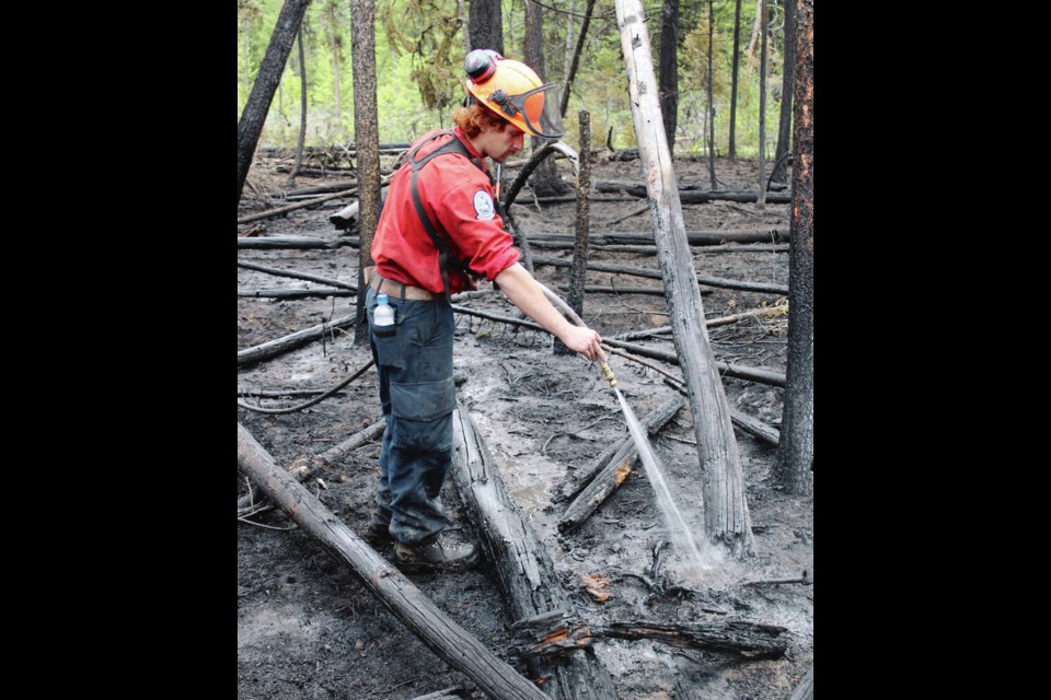 A crew member works at the ­Watching Creek fire near Kamloops in August. Wildfires that burned 870,000 hectares in B.C. in 2021 laid the groundwork for the devastation of last Novembers floods and landslides by disrupting the landscapes ability to absorb water.  B.C. Wildfire ­Service 