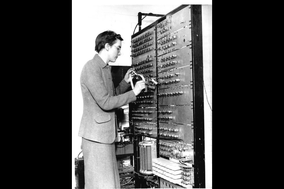 Kathleen Booth in the 1950s, loading a program into the All Purpose Electronic (X) Computer, known as the Apexc, which she designed with her husband. Family photo