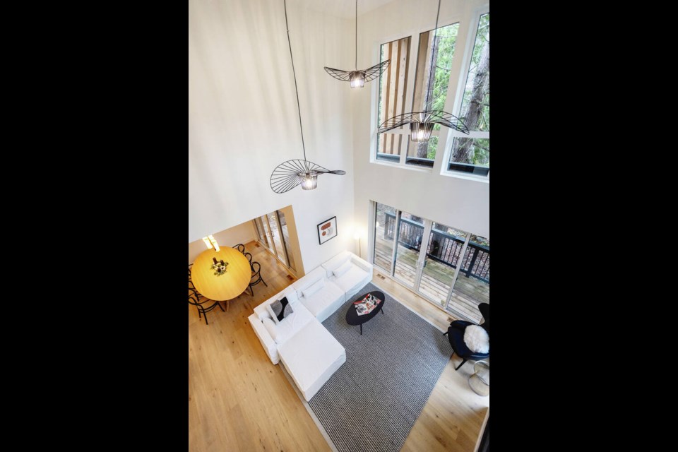 An aerial view of the living room shows three pendant lights that were hung at varying heights. A similar pendant light is in the entryway hallway. DARREN STONE, TIMES COLONIST 