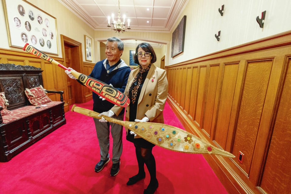 Lt.-Gov. Janet Austin and First Nations award committee adviser ­Patrick Kelly show the canoe paddles installed at Government House on Tuesday to launch the 2023 B.C. Reconciliation Awards. The 2021 paddle, left, was created by Kwakwaka’wakw artist Cole Speck, and the 2022 paddle, right, was created by Dene and Carrier beader ­Crystal Behn. The B.C. Reconciliation Awards is a partnership between the Office of the ­Lieutenant Governor of British Columbia and the B.C. Achievement Foundation, and recognizes people, groups and organizations that have demonstrated exceptional leadership, integrity, respect and commitment to furthering reconciliation or inspiring others to continue reconciliation efforts. DARREN STONE, TIMES COLONIST