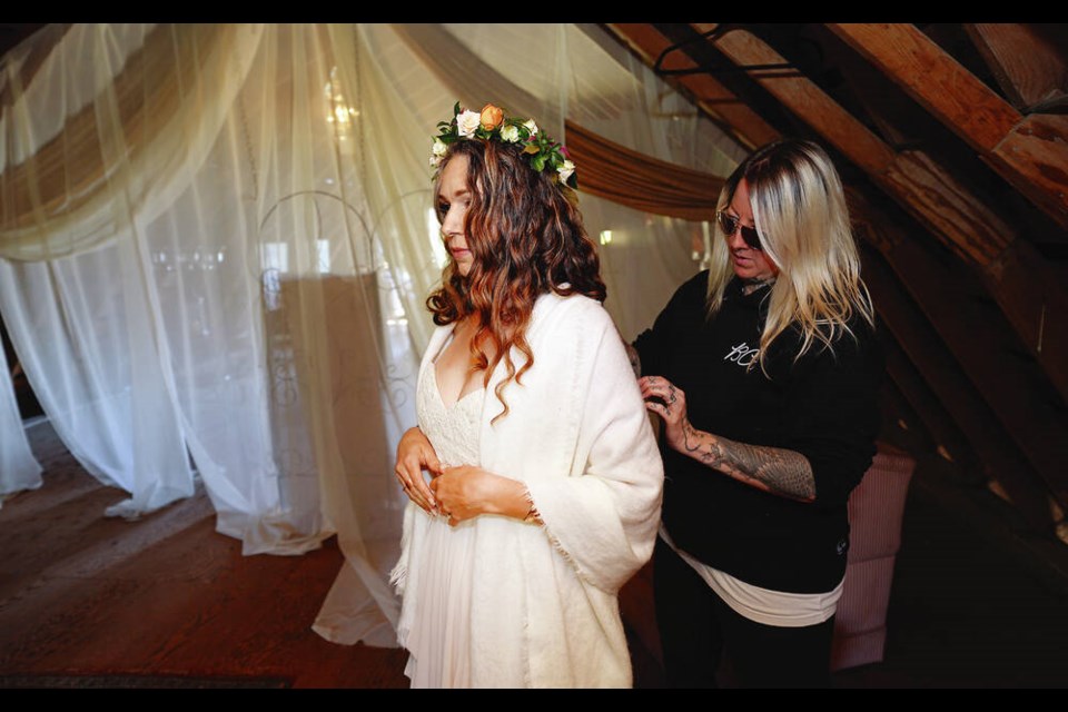 Lily Kennedy of Lily Kennedy Custom Gowns gets bride Giselle Ruemke-Leigh ready before her wedding at ­Kildara Farms in North Saanich.  ADRIAN LAM, TIMES COLONIST 
