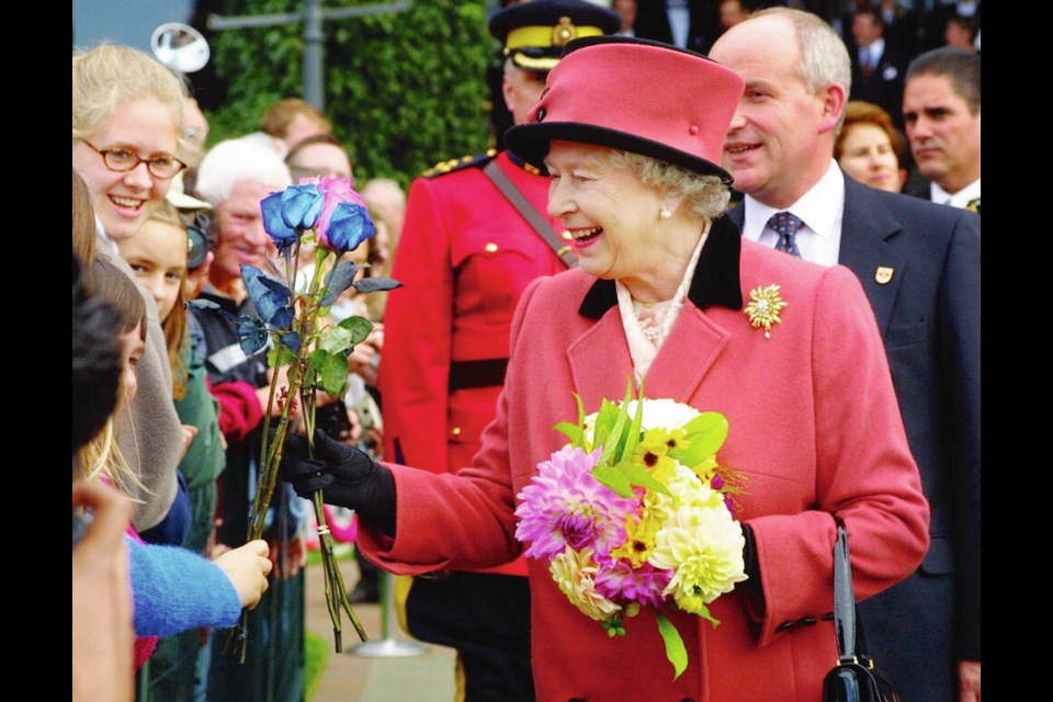The Queen accepts flowers outside the Empress Hotel on Oct. 6, 2002.  ROB KRUYT, VANCOUVER SUN