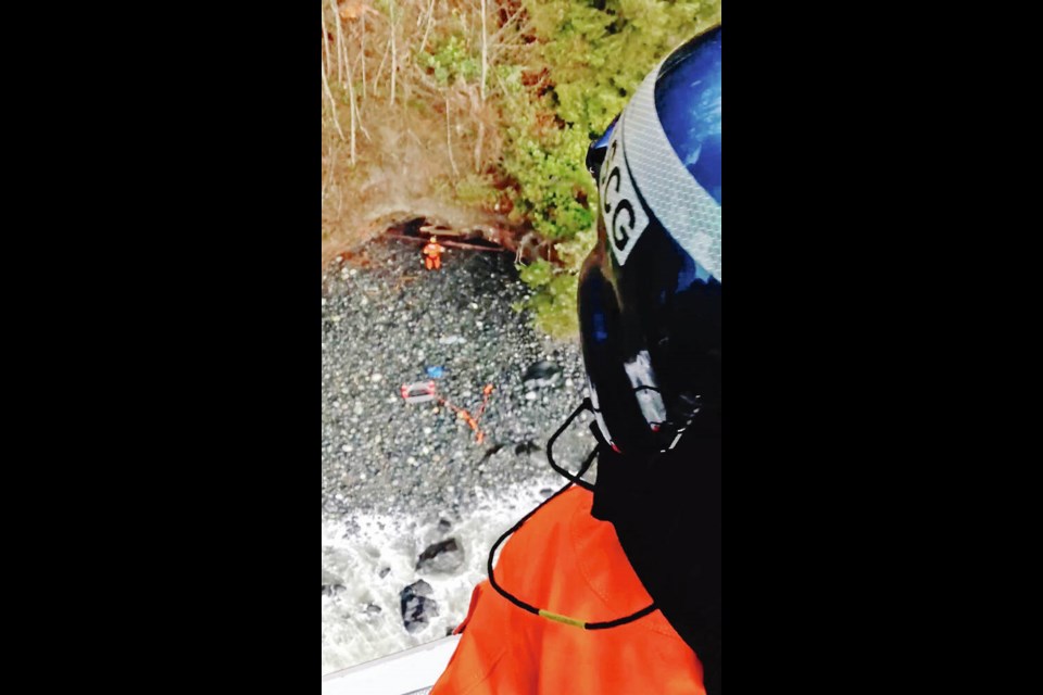 Dramatic rescue: A lone man and a dog were pulled to safety from a sailboat that had washed onto rocks near Jordan River by a crew from the United States Coast Guard Air Station Port Angeles. Another dog was picked up later. U.S. COAST GUARD 