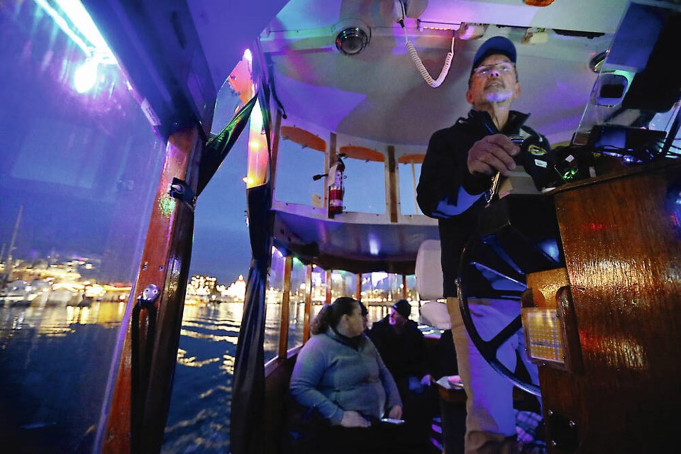 Capt. Paul Thomas pilots one of Victoria Harbour Ferry's little boats on a tour of the harbour Wednesday night. The tour is being enhanced in December with a 45-minute show called Victoria Harbour Lights: A Winter Dream. It's a narrated show with music that features sound-reactive light installations and projections on industrial sites. PHOTOS BY ADRIAN LAM, TIMES COLONIST 