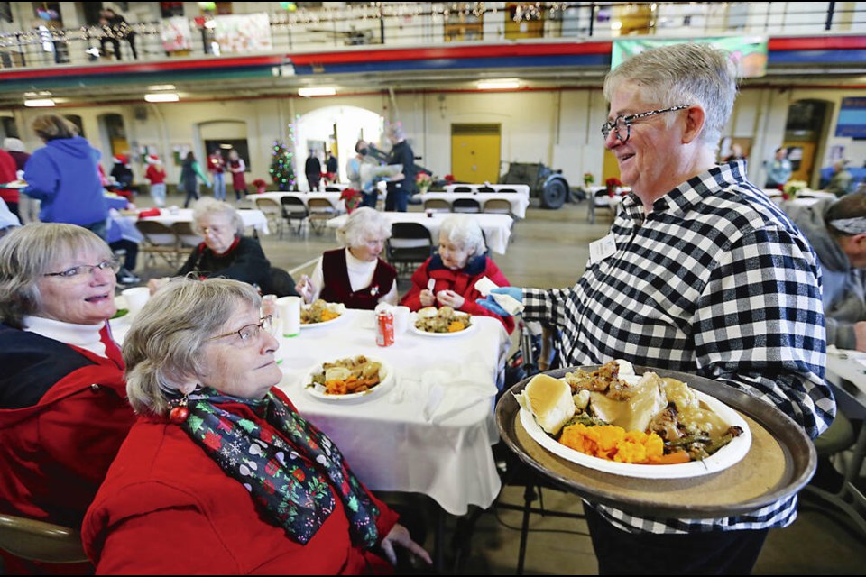 Victoria Mayor Marianne Alto, right, serves food and chats with Linda Murdock and Barb Jones, who were among the hundreds of ­people who gathered to enjoy the annual Mustard Seed Christmas Dinner at the Bay Street Armoury on Saturday. ADRIAN LAM, TIMES COLONIST   Dec. 10, 2022
