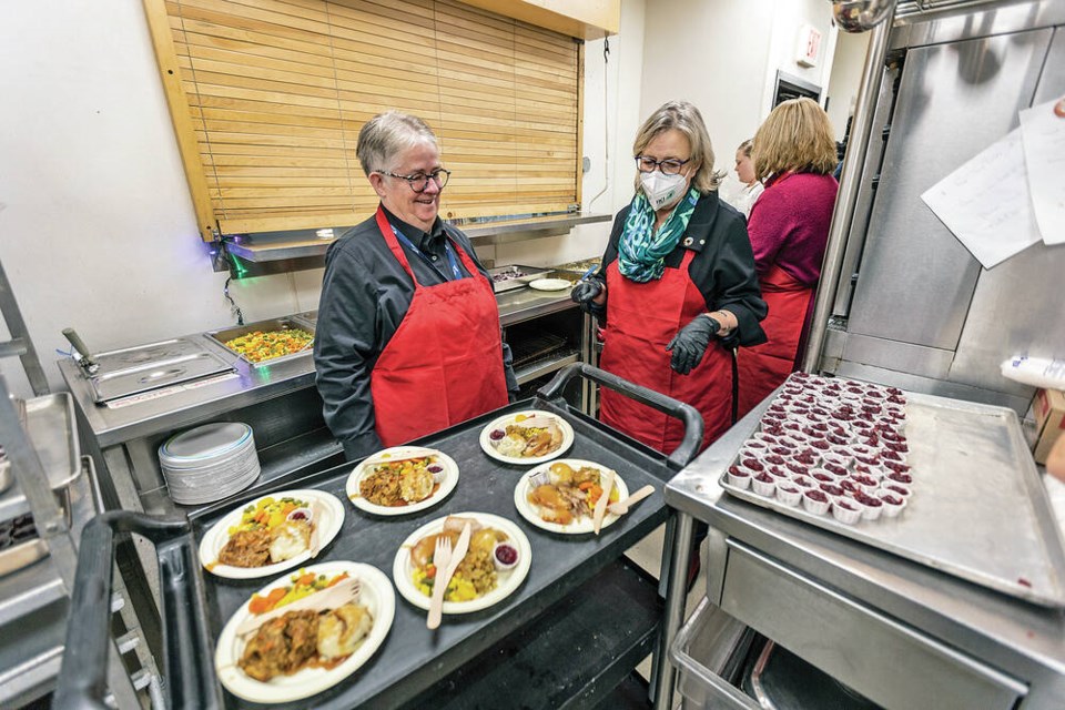 Victoria Mayor Marianne Alto, left, and federal Green Party leader Elizabeth May serve lunch at Our Place on Wednesday. DARREN STONE, TIMES COLONIST 