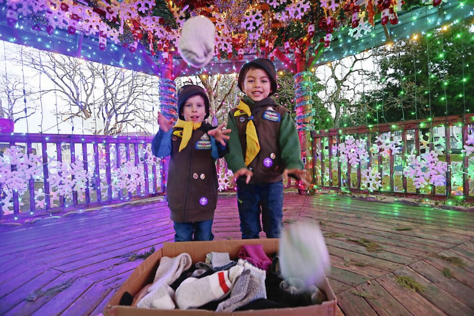 Scott Charles, 5,left, and Simon Swan, 6, throw rolled-up socks used in an indoor snowball fight before being donated for those in need. ADRIAN LAM, TIMES COLONIST 