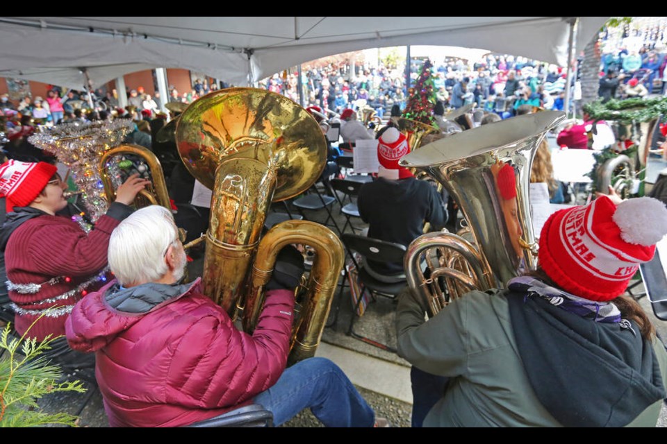 Dozens of tuba players perform Christmas tunes for hundreds of people at Market Square on Saturday afternoon. Tuba Christmas is an annual event that celebrates the low notes of music, bringing together volunteer musicians from the Island and Lower Mainland. ADRIAN LAM, TIMES COLONIST 