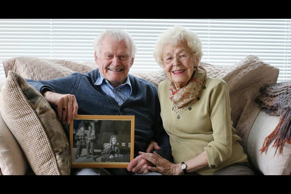 Lew and Joan Duddridge, with a photo of Joan first arriving to Canada as a war bride, at their home in 2013. Lew died Jan. 4 at the age of 104. ADRIAN LAM, TIMES COLONIST 