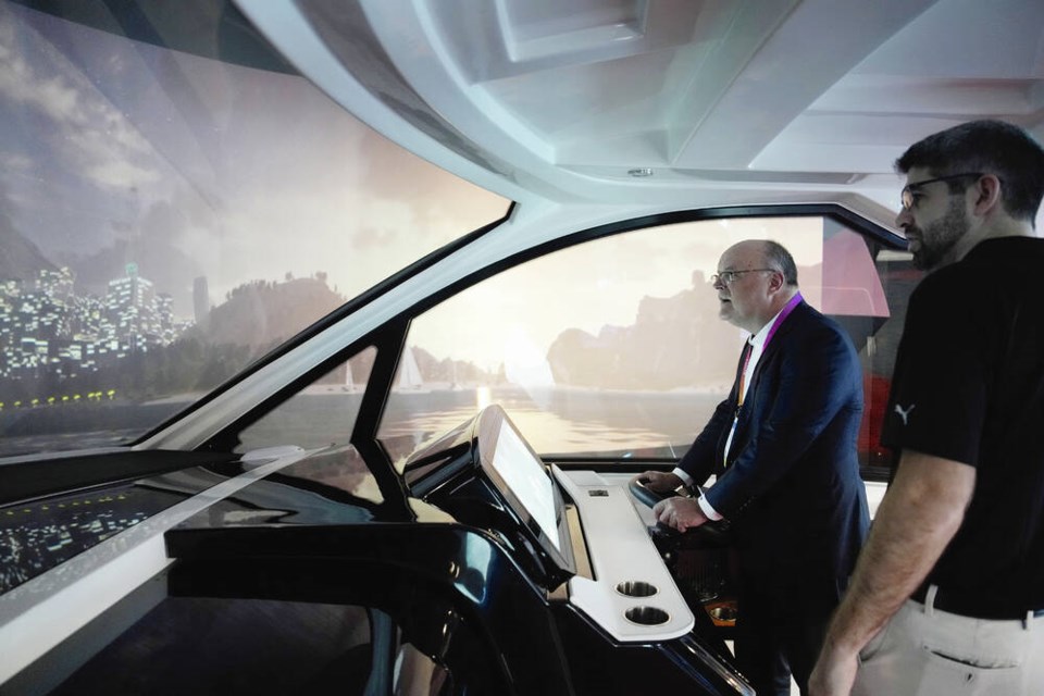 Norbert Brosi drives a boat on the Future Helm boat simulator at the Brunswick booth during the CES tech show Friday, Jan. 6, 2023, in Las Vegas. The technology was on display at the booth to allow convention goers to experience auto boat docking and other technologies both in use and in development. (AP Photo/John Locher) 