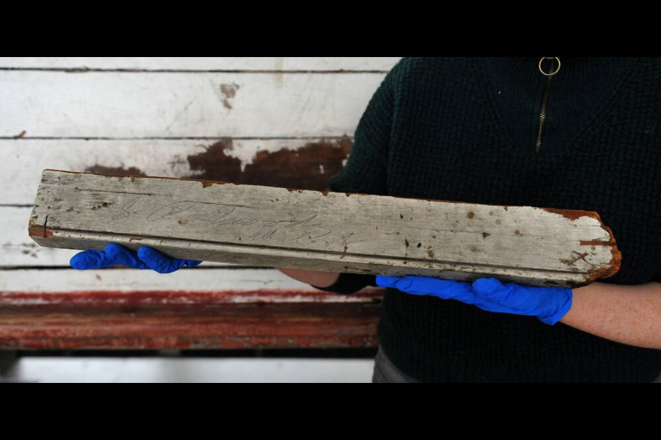Mary Elizabeth Harrison, a curator at the Vancouver Maritime Museum with a piece of wood bearing the signature of Sewell Moody with the words All Lost that was recovered from a beach in Victoria in December 1875 following the wreck of the Pacific. NICK PROCAYLO, PNG 