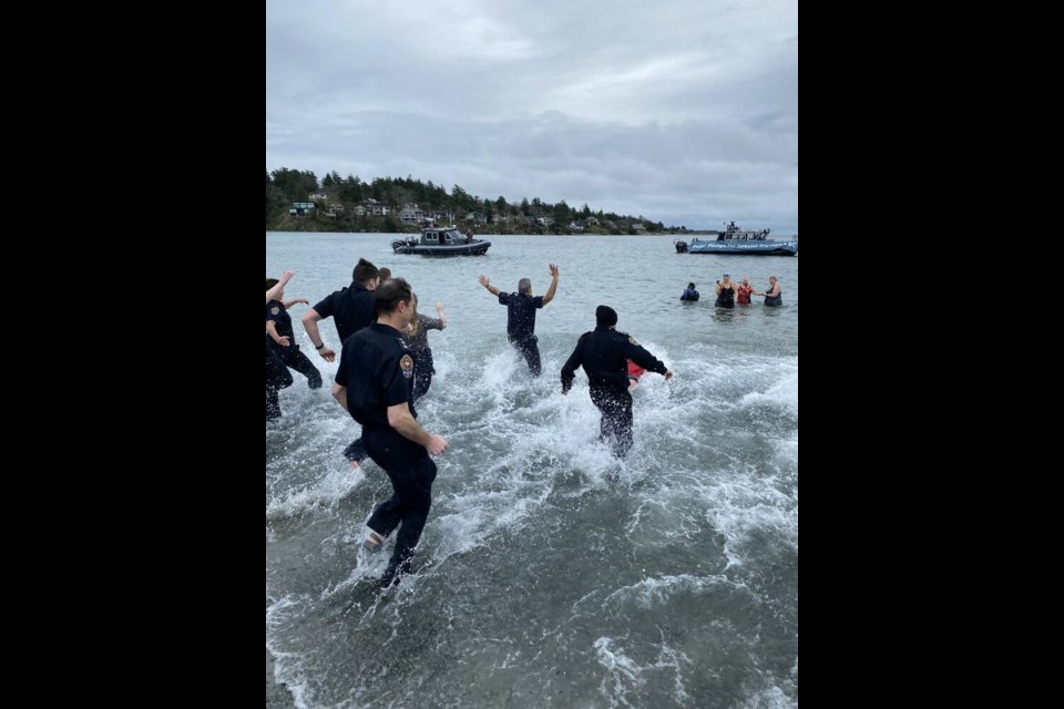 Victoria Police Chief Del Manak leads the way in Sunday's fundraising Polar Plunge in the frigid waters at Cadboro Bay in Saanich. TIMES COLONIST 