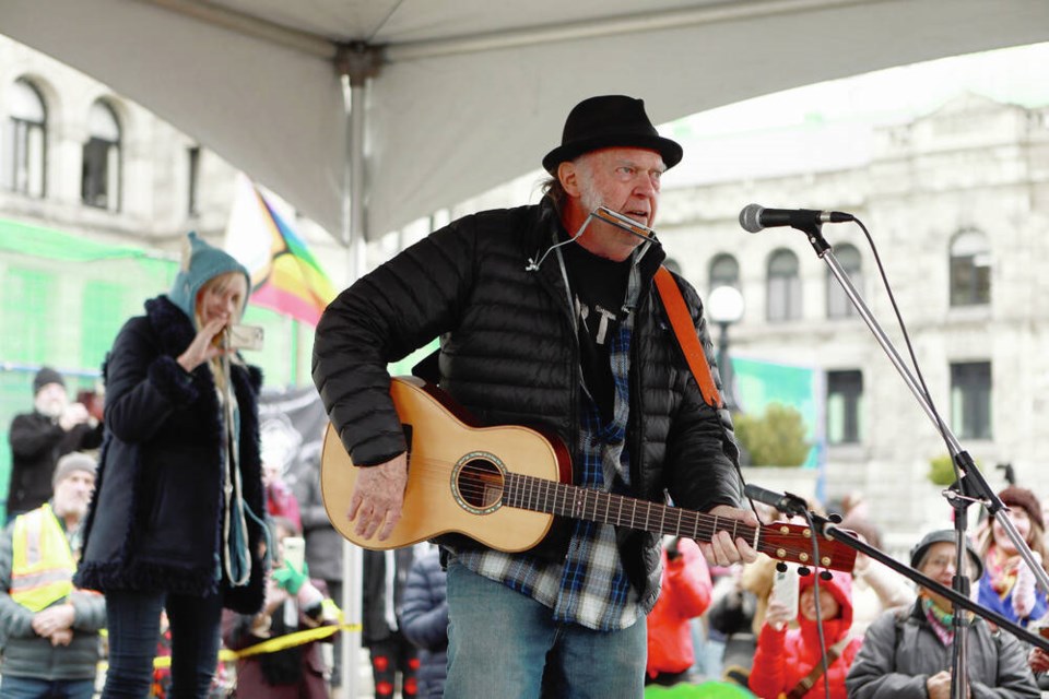 Rock legend Neil Young performs during a rally against the destruction of old growth forests on the front lawn of the legislature in Victoria, B.C., on Saturday, February 25, 2023. THE CANADIAN PRESS/Chad Hipolito 