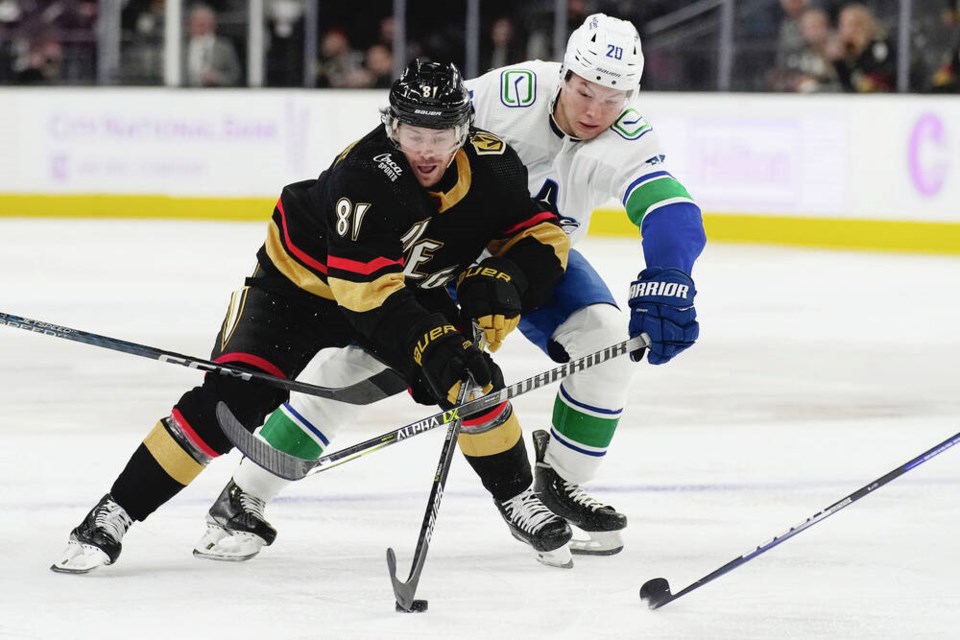 Vegas Golden Knights centre Jonathan Marchessault and Vancouver Canucks centre Curtis Lazar battle for the puck during an NHL game, Nov. 26, 2022, in Las Vegas. With both an NHL and NFL team in the city, Las Vegas is now a thrilling sports destination.  THE ASSOCIATED PRESS
