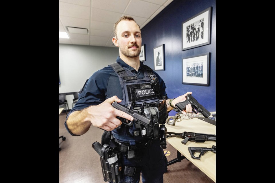 One of the weapons VicPD Const. Kale Howe is holding is a replica — can you tell which one? (The replica is on the left.) DARREN STONE, TIMES COLONIST 