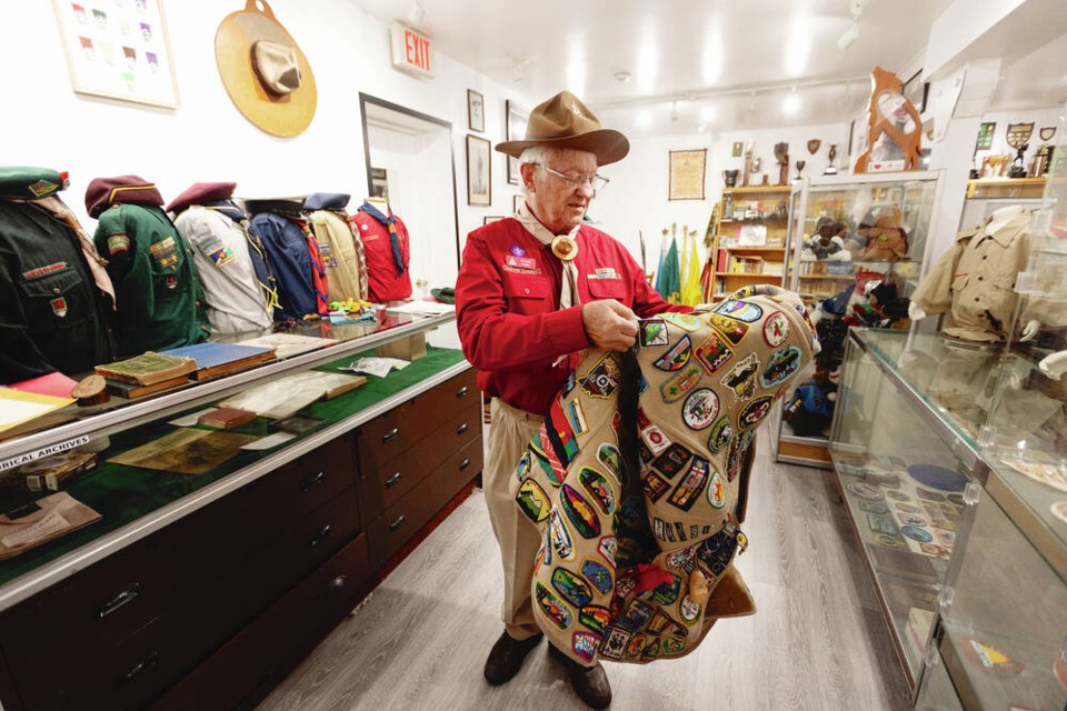 Richard Druce holds a camp blanket covered in badges in the new Victoria Scout Museum at Scout House at 505 Marigold Rd. DARREN STONE, TIMES COLONIST 