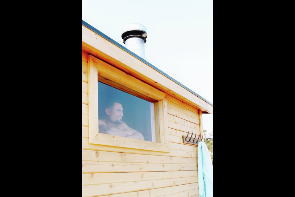 Josh Dupuis, owner of Wildwood Saunas, looks out of one of his mobile sauna units parked along Ocean Boulevard in Colwood. CONTRIBUTED PHOTO