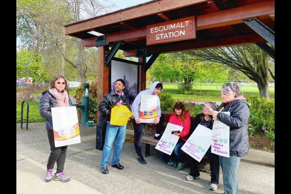 Rinu Cassells, second from left, Vicky Killion, fourth from left, and Sue Taylor, right, take a break on the picket line at Esquimalt Graving Dock. Remote work, they say, is a key part of negotiations for them. TIMES COLONIST 