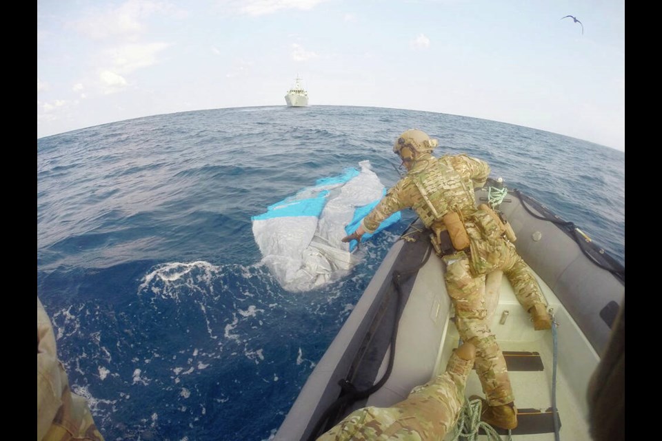 Sailor investigates suspected contraband jettisoned from ship off Mexico. Via Department of National Defence. 