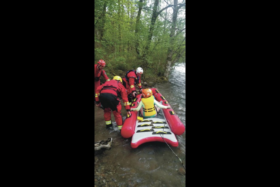 Search and rescue crews bring two girls back to shore on a rescue sled after they became stranded in the Puntledge River with their father. COMOX VALLEY SEARCH AND RESCUE 