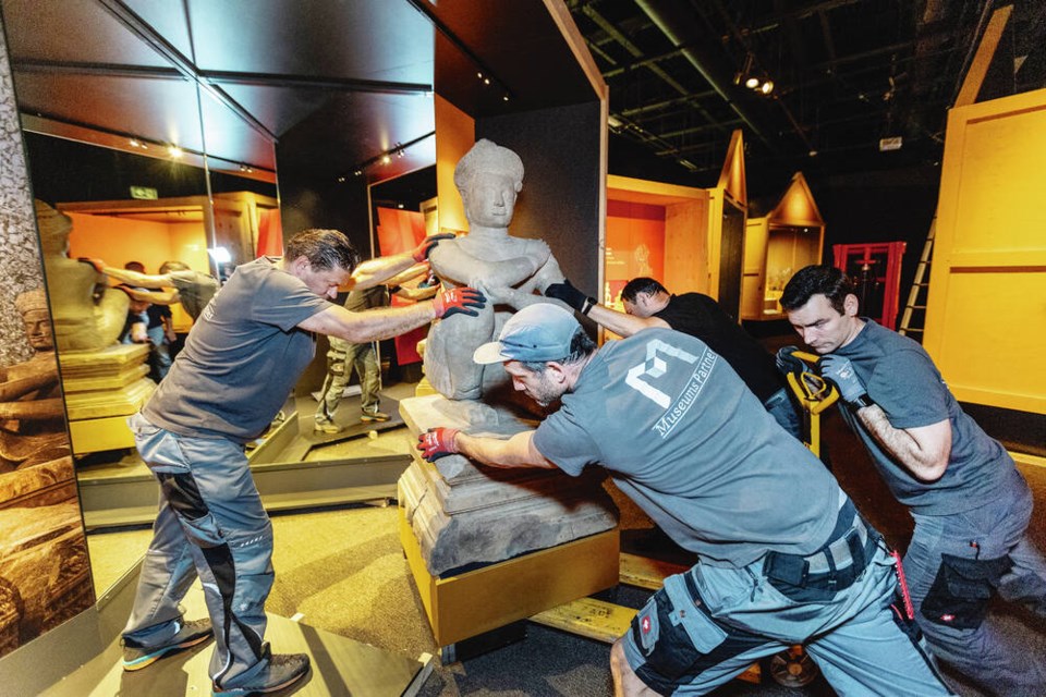 From left, Hans Christian Geiler, Trent Rocker, Manfred Wittman and Tobias Wittman install a 10th-century sandstone sculpture of Pandava Sahadeva for the upcoming Angkor Wat exhibit at the Royal B.C. Museum. DARREN STONE, TIMES COLONIST 