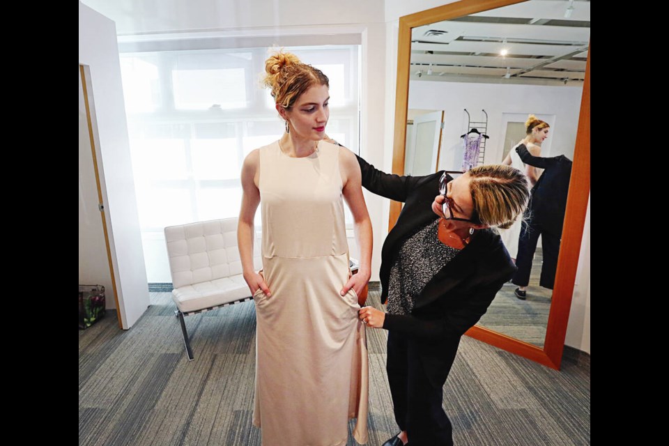 Olivia Hahn has a dress fitted by Rebecca Burrows, the owner of Hughes Clothing, for a fashion show to raise money for a cancer charity. ADRIAN LAM, TIMES COLONIST 