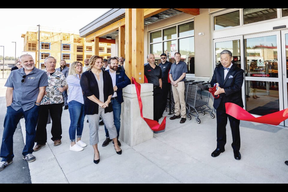 Colwood Mayor Doug Kobayashi cuts a ribbon at the official opening of The Commons Retail Village at Royal Bay on Thursday. DARREN STONE, TIMES COLONIST 