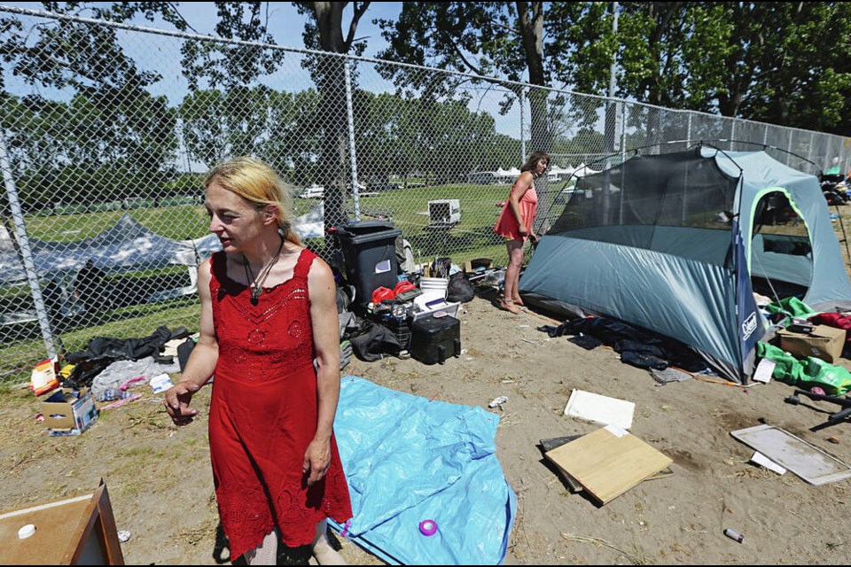 Amanda, left, and Cailin set up camp on the other side of the fence from the Highland Games in Topaz Park. ADRIAN LAM, TIMES COLONIST 