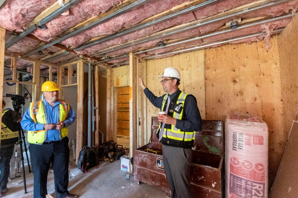 Malcolm McNaughton, Keycorp Consultings director of planning and business development, left, and Langford Mayor Scott Goodmanson tour a one-bedroom unit at the Trailside at the Lake condo complex under construction on Goldstream Avenue. DARREN STONE, TIMES COLONIST 
