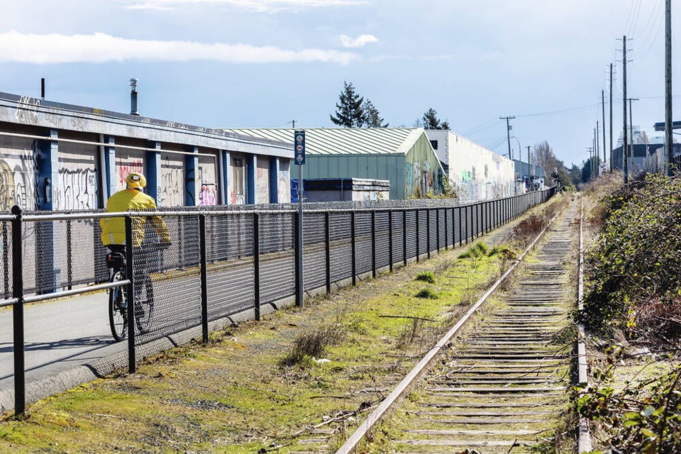A cyclist passes unused rail tracks near the Lampson Street crossing. DARREN STONE, TIMES COLONIST 