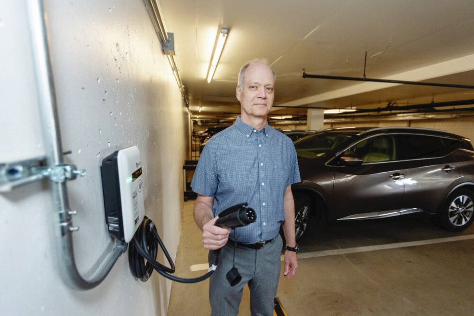 Jim Church with one of the charging stations installed in his Cordova Bay condominium complex. DARREN STONE, TIMES COLONIST 