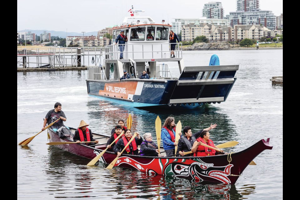 The war canoe Salish Seawolf passes the Western Canada Marine Response Corporation landing craft Cheanuh Sentinel as First Nations Marine Teams from southern Vancouver Island gathered in Victoria's Inner Harbour on Friday. DARREN STONE, TIMES COLONIST 