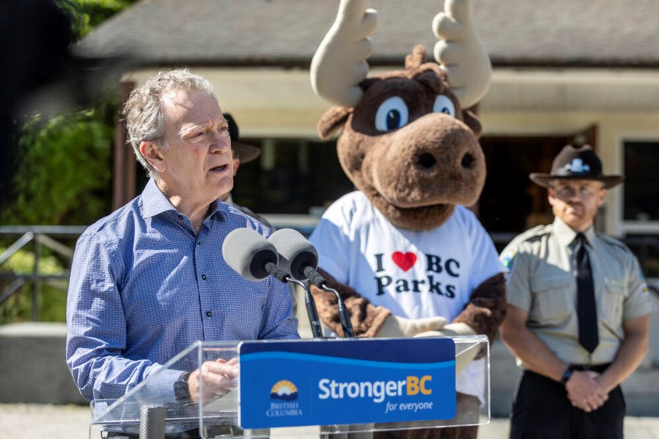 Environment Minister George Heyman - and a couple of special friends - announces funding for the B.C. Parks Foundation at Goldstream Provincial Park on Thursday. DARREN STONE, TIMES COLONIST 