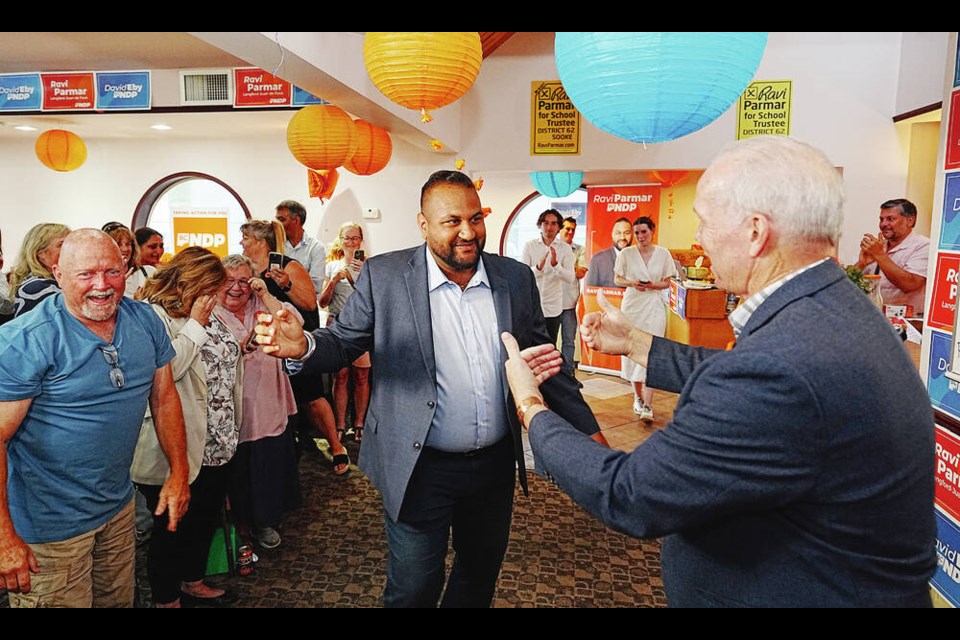 Ravi Parmar, left, receives congratulations from John Horgan on Saturday night. Parmar won the Langford-Juan de Fuca byelection for the NDP, taking over the seat from Horgan, who had held it since 2005. ADRIAN LAM, TIMES COLONIST VICTORIA, B.C.: June, 24, 2023 - Ravi Parmar wins John Horgans former seat in the provincial riding of Langford-Juan de Fuca. VICTORIA, B.C. June 24, 2023. (ADRIAN LAM, TIMES COLONIST). For Business story by Carla Wilson. 
