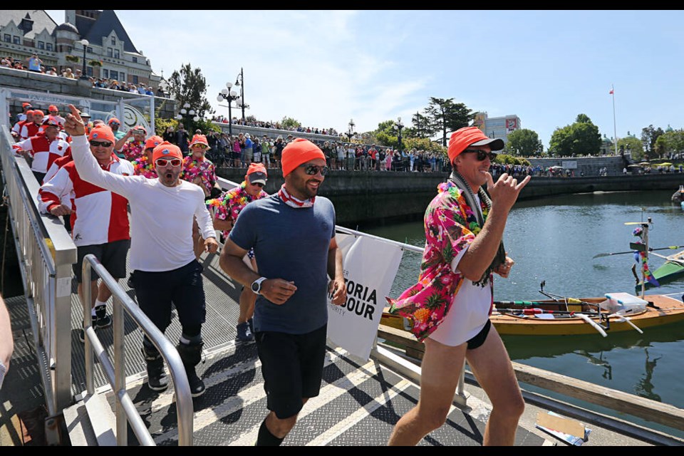 Competitors race down the gangplank to their boats in Victoria's Inner Harbour as the second leg of the Race to Alaska gets underway at noon Thursday. ADRIAN LAM, TIMES COLONIST 