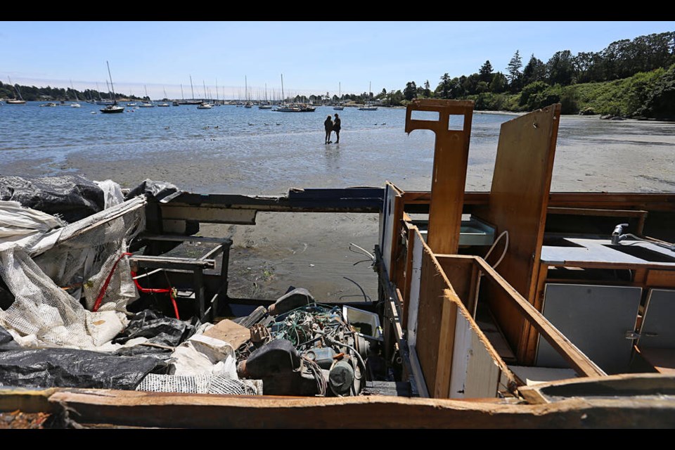 The owner of the Akoo, a 27-foot white-hulled cabin cruiser aground in Cadboro Bay in Saanich, has been fined $15,000 for failing to remove the vessel. ADRIAN LAM, TIMES COLONIST 