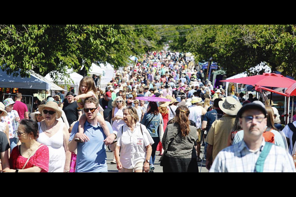 People stroll Moss Street on Saturday for the annual Paint-In, which features the work of local artists. ADRIAN LAM, TIMES COLONIST 