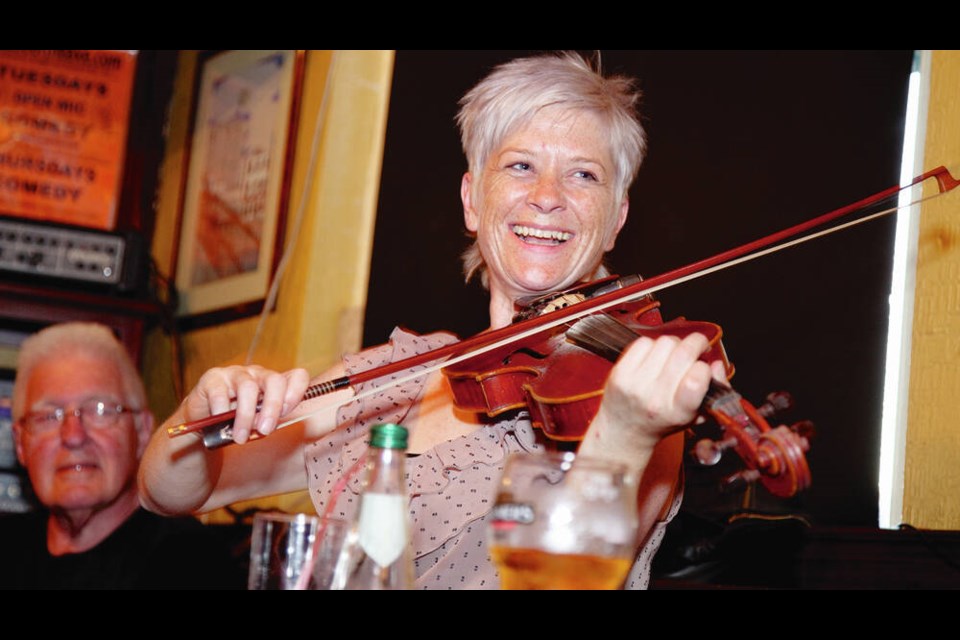 A woman plays the fiddle in a Dublin pub. To find an Irish music session in a pub, wander a town and follow your ear. DOMINIC ARIZONA BONUCCELLI 