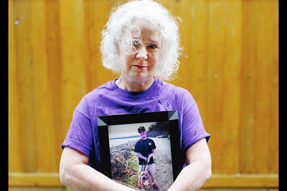 Jenny Howard, Victoria-based B.C. program manager for Moms Stop the Harm, holds a photograph of her late son, Robby, died of a toxic drug overdose in May of 2016. ADRIAN LAM, TIMES COLONIST 