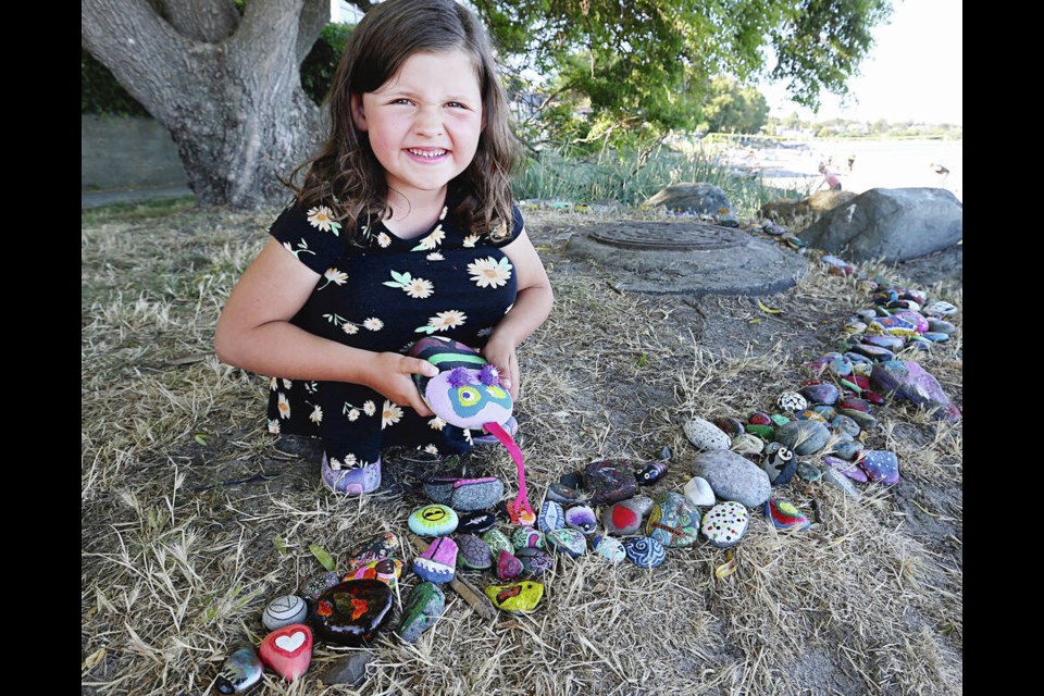 Rosie Holoiday, 6, with Roxy the rock snake at the south end of Willows Beach. ADRIAN LAM, TIMES COLONIST 