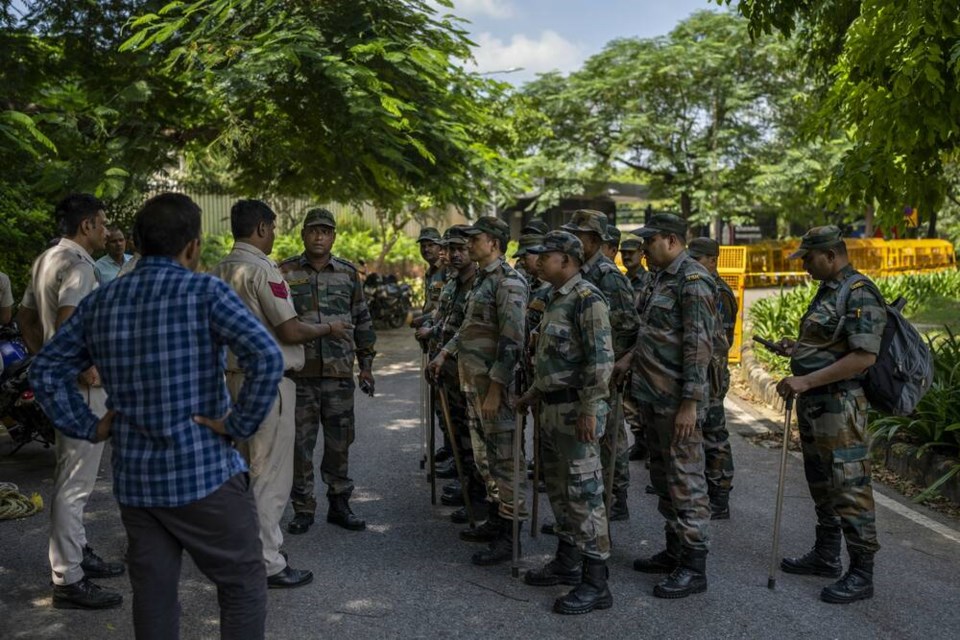 A Delhi police officer briefs a group of Indian paramilitary soldiers outside the Canadian High Commission in New Delhi, India, Tuesday, Sept. 19, 2023. (AP Photo/Altaf Qadri)