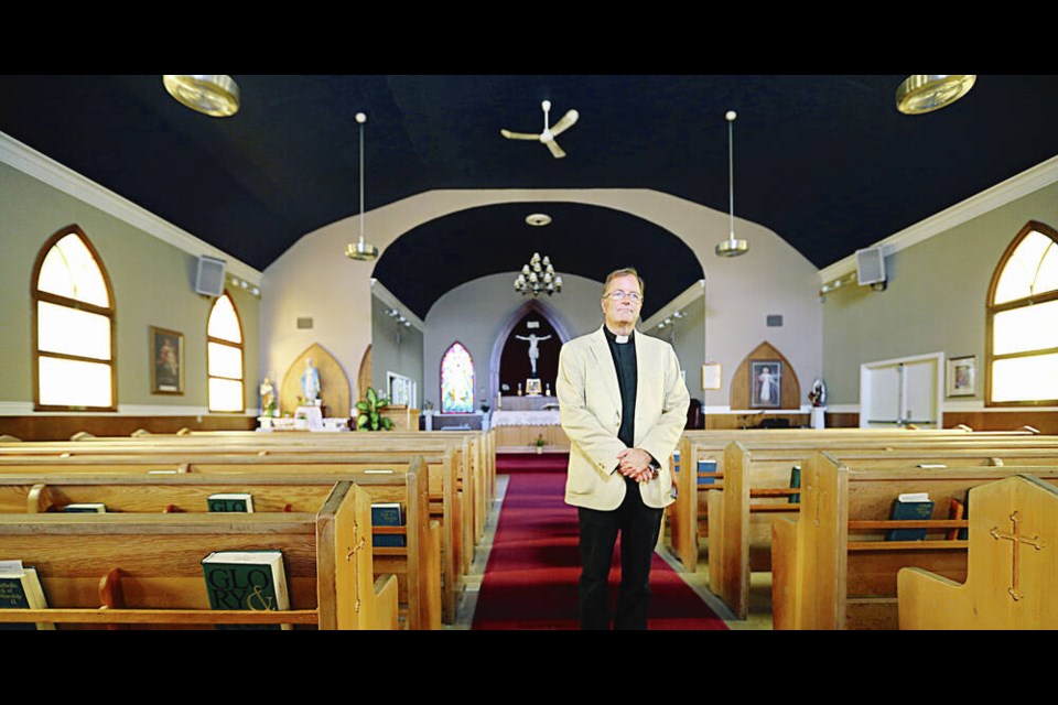 Father Dean Henderson in the Our Lady of the Rosary Parish church in Langford. The church is being torn down in October to make way for a new West Shore post-secondary campus in Langford. ADRIAN LAM, TIMES COLONIST 