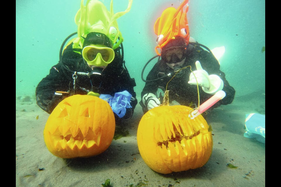 Divers participating in an underwater pumpkin carving event pose in the waters off Ocean Boulevard. VIA TIARE BOYES 
