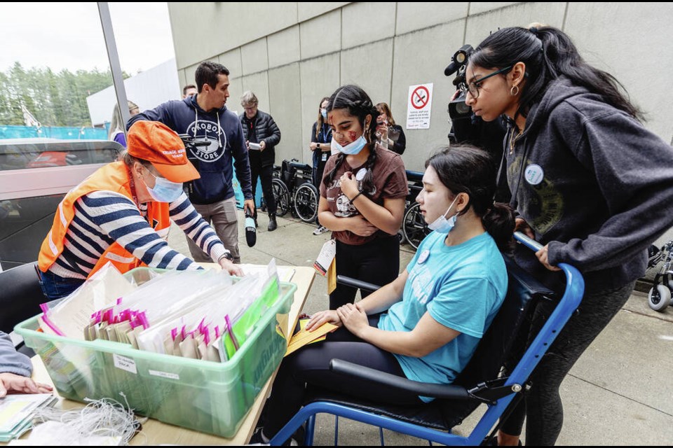 Triage worker Cindy-Lynn Loucks, left, gets information from simulated bus crash victims Megan Salaga, right in wheelchair, and Devika Mital during a code orange training exercise at Victoria General Hospital on Friday. DARREN STONE, TIMES COLONIST 