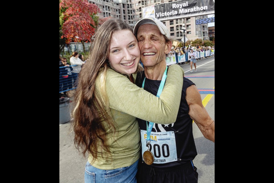 Keith Parks with his daughter Victoria Parks after finishing his 200th marathon at the Royal Victoria Marathon on Belleville Street in Victoria on Sunday. DARREN STONE, TIMES COLONIST 