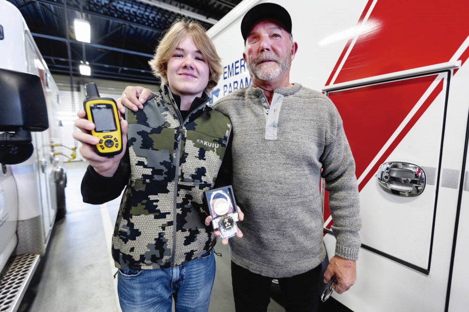 Thirteen-year-old Carter Burkard shows the GPS device he used to help rescue his grandfather, John ­Burkard, right, after an ATV accident. The teen was presented with a Good Samaritan Award by 
B.C. Emergency Health Services in Victoria on Thursday. Story, A3 DARREN STONE, TIMES COLONIST 