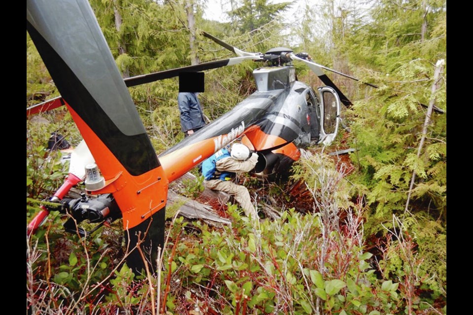 Investigators examine the crashed helicopter in April 2022. TRANSPORTATION SAFETY BOARD 