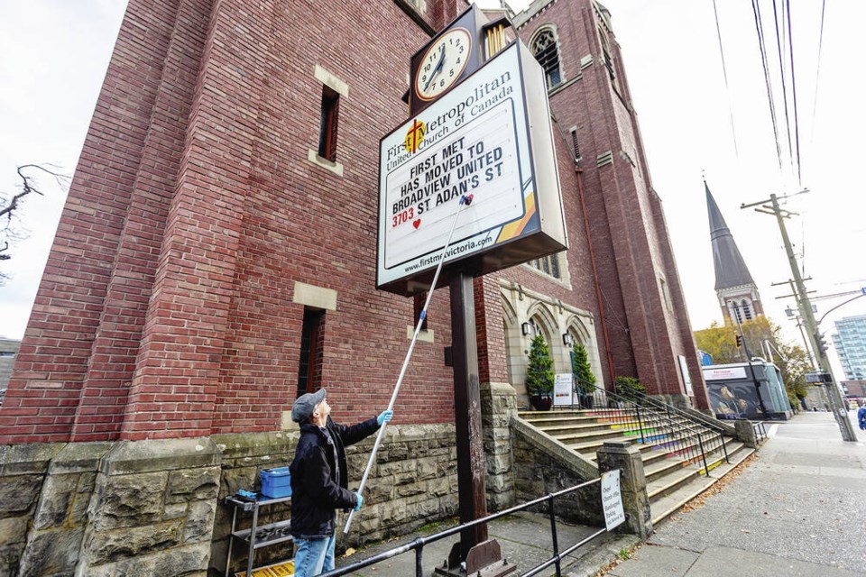 Former building superintendent Bruce Davies puts up the moving sign outside First Metropolitan United Church on Quadra Street. 
DARREN STONE, TIMES COLONIST 