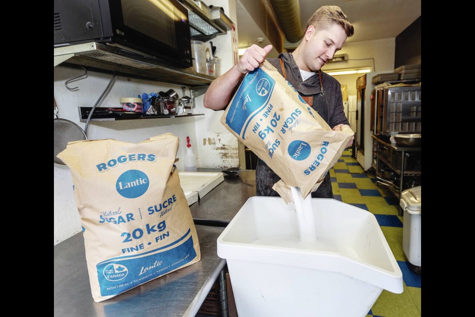 Pastry chef Keigan Stoddart pours Rogers sugar to make shortbread cookies at Ruth & Dean Luncheonette and Bakery on Estevan Avenue in Oak Bay. DARREN STONE, TIMES COLONIST 